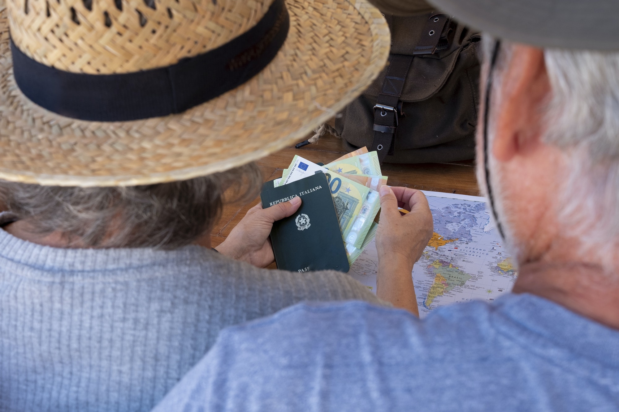 Rear view of senior couple planning a vacation travel around the world Rear view of senior couple planning a vacation travel around the world